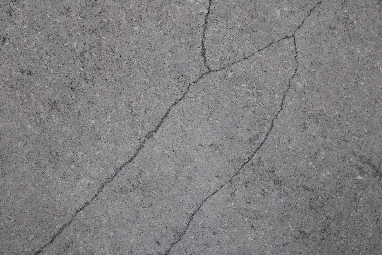 Cracked gray asphalt surface, with a diagonal crack running through the middle.