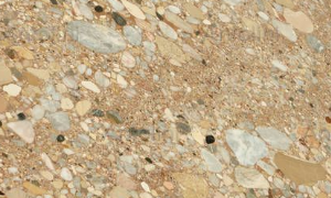 Close-up of beige terrazzo flooring with embedded pebbles of various colors.