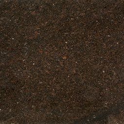 Close-up of dark brown soil with small flecks of lighter material.