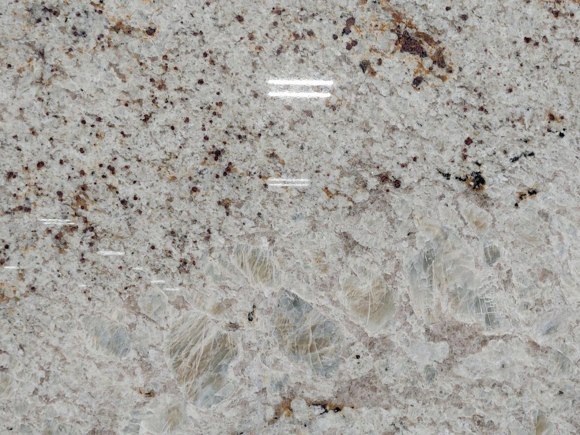 Close-up of a polished granite countertop with speckled beige, brown, and blue-gray patterns.