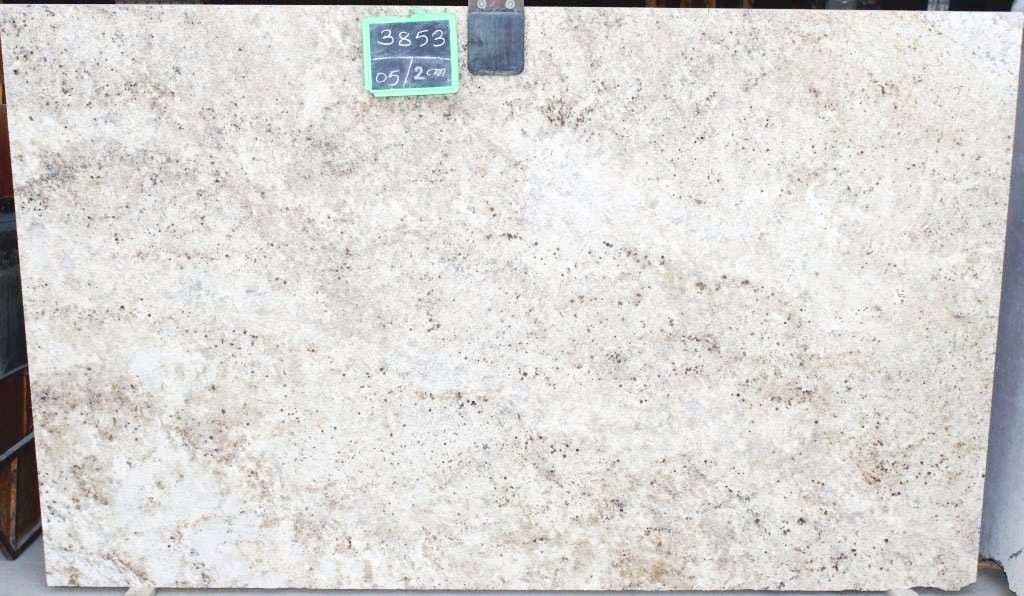 Cream and brown granite slab with small dark flecks, price tag attached.