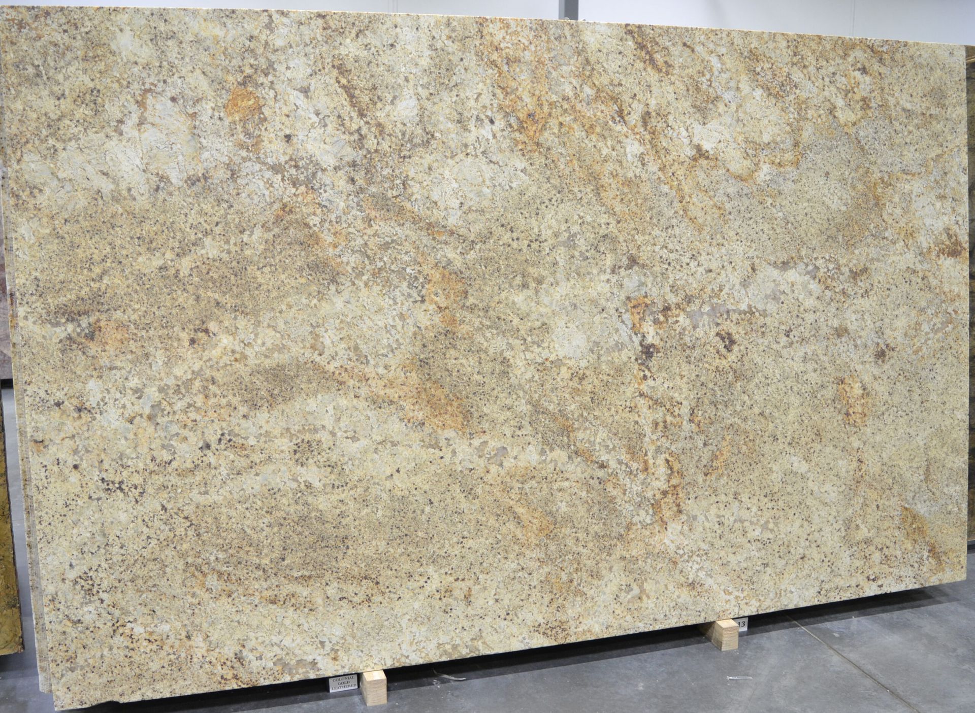 Large, beige granite slab with gold and brown veining.