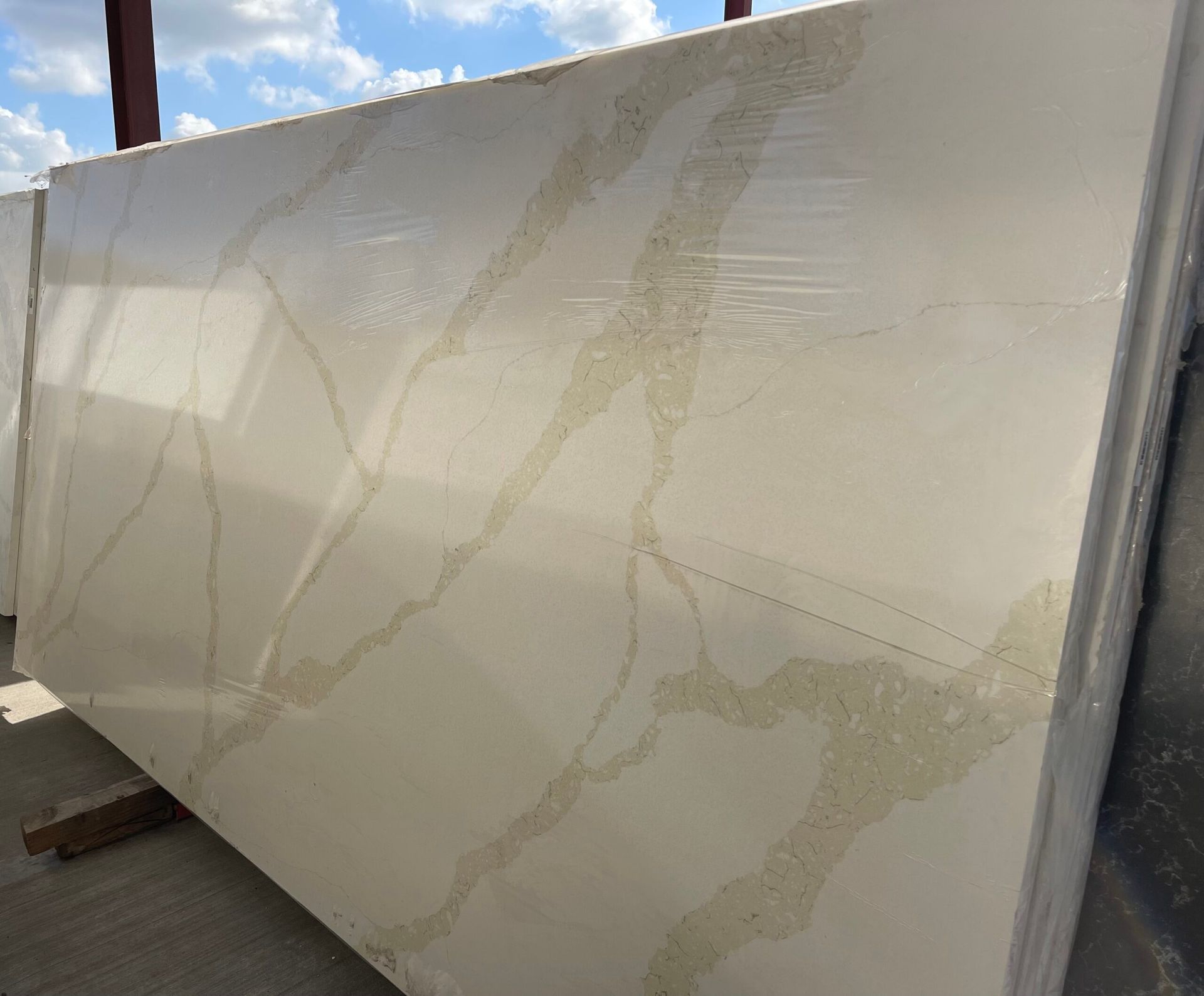 Cream-colored slab of stone with gold veining, likely a countertop material.