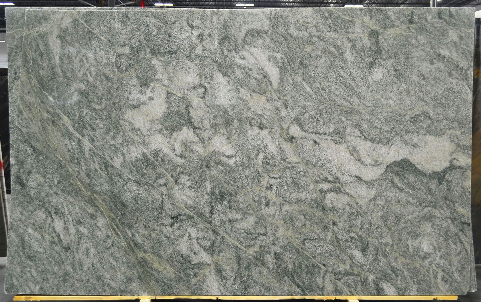 Green and gray granite slab with swirling patterns.