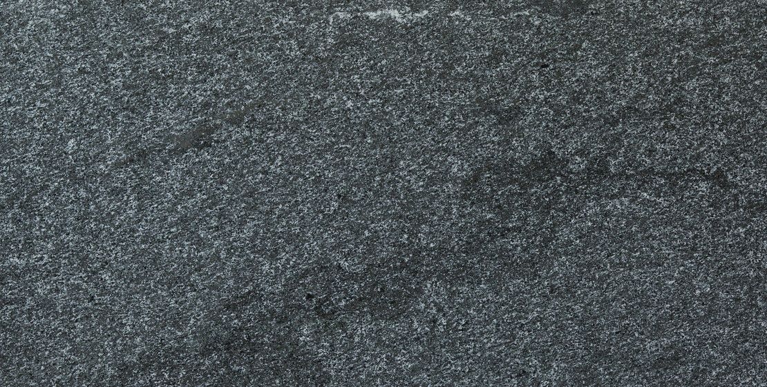 Close-up of dark gray, textured material, possibly steel wool or a similar abrasive pad.