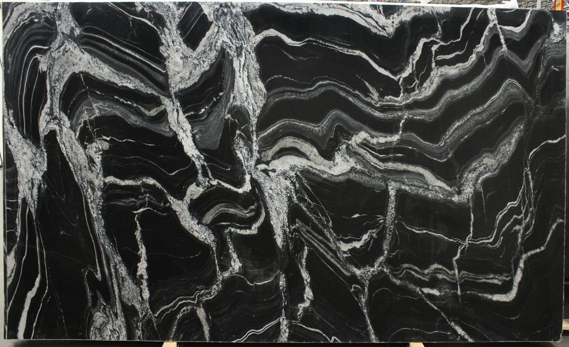 Black granite slab with swirling white and gray veining.