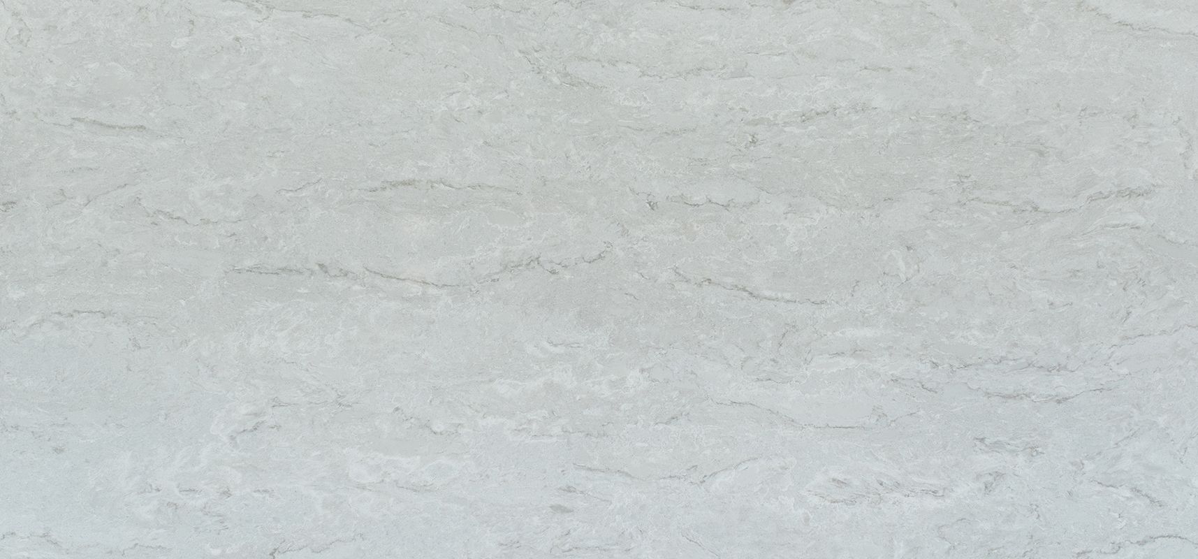 A close-up of a light gray surface with subtle, flowing patterns, possibly stone or a similar material.