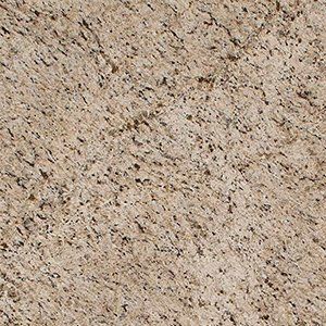 Close-up of beige granite with dark, irregular markings throughout.