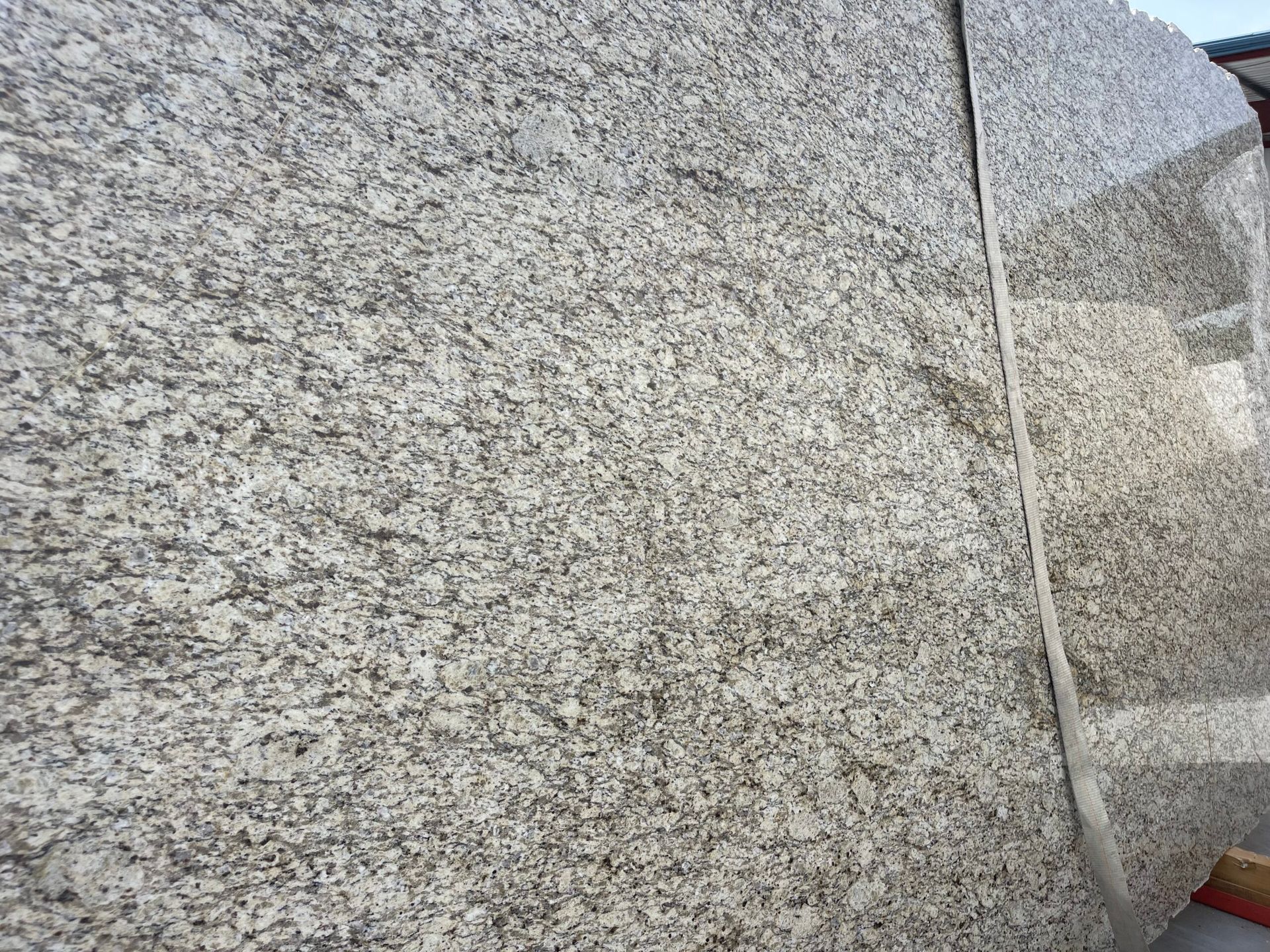 Gray and beige granite slab with a speckled pattern.