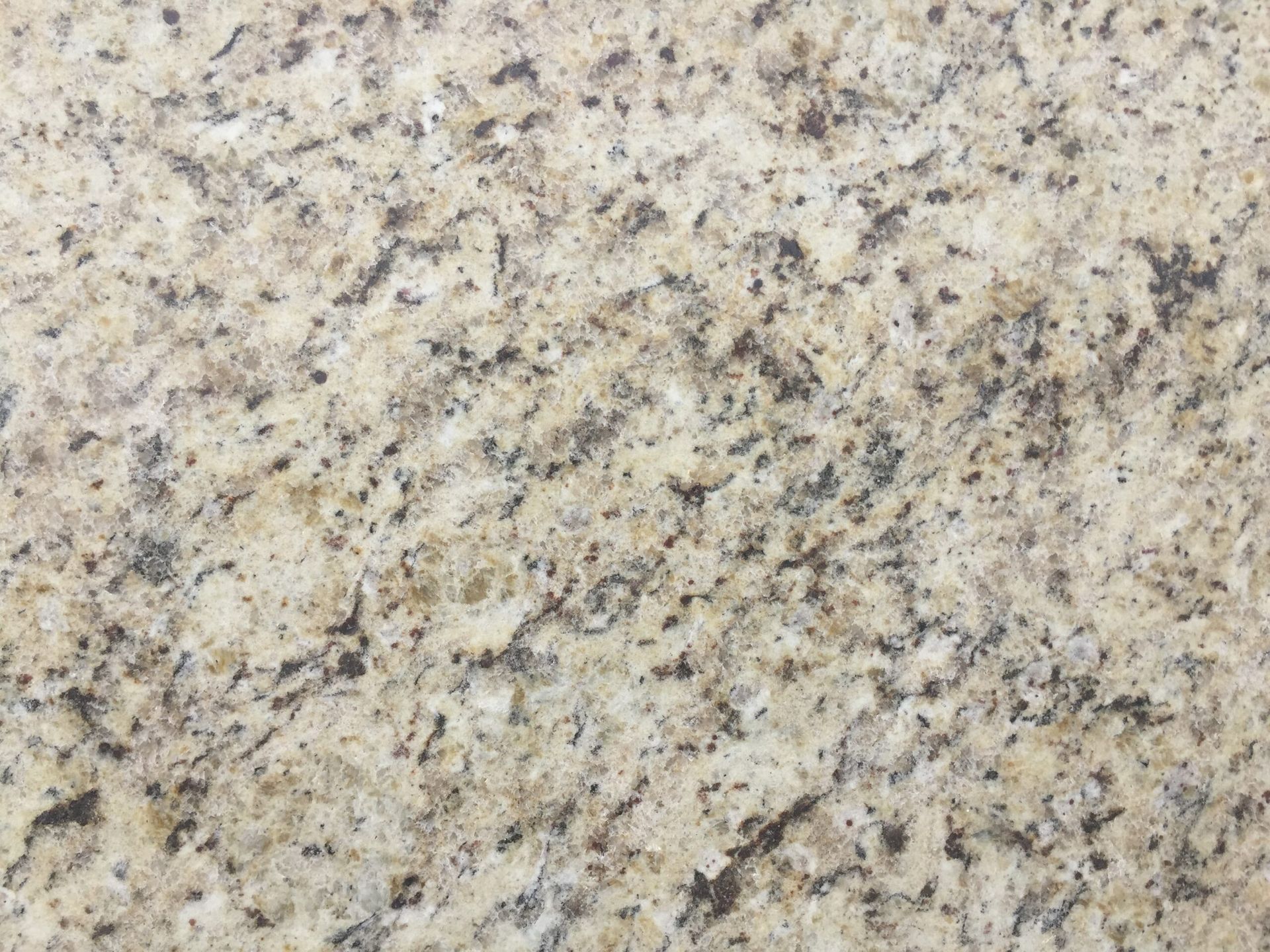 Cream-colored granite countertop with black and gray flecks.