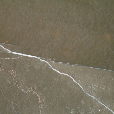 Dark brown marble tile with white and gold veining.