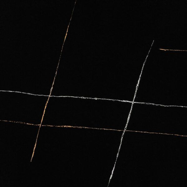Black surface with white and gold linear veining.