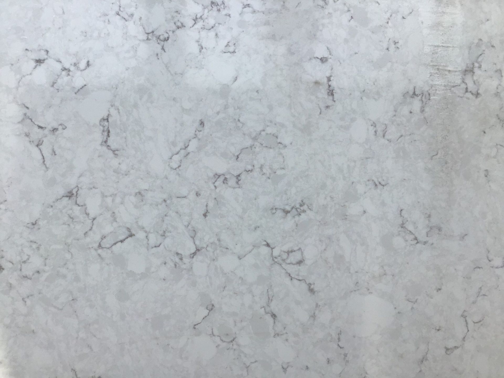 Gray quartz countertop with veining pattern.