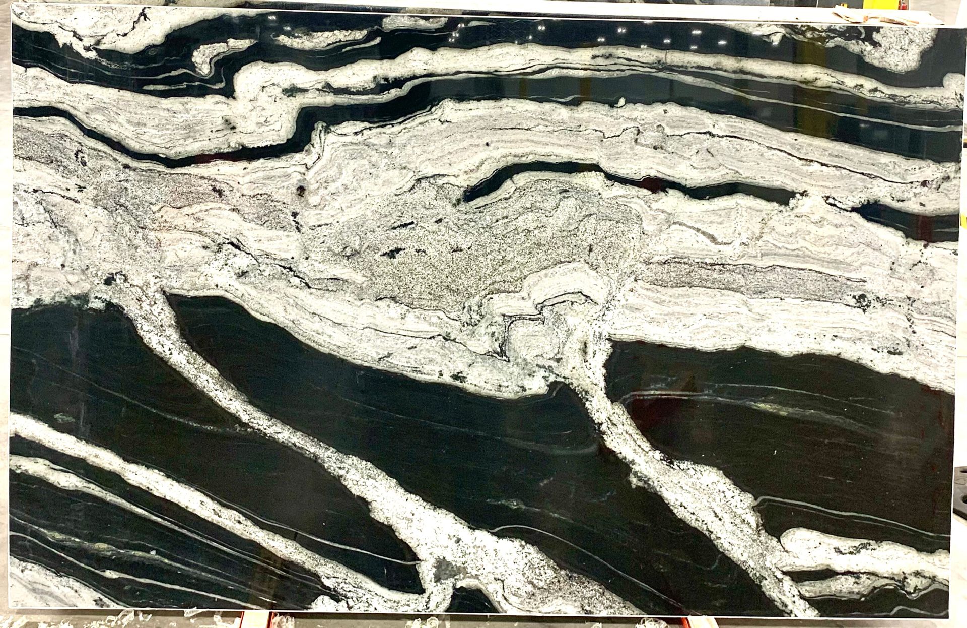 Black, white, and gray granite slab with flowing wave-like patterns.
