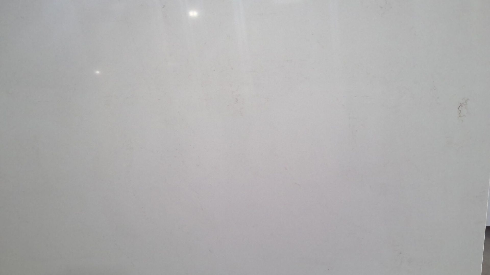 Off-white, smooth surface, possibly a wall or countertop, with small imperfections.