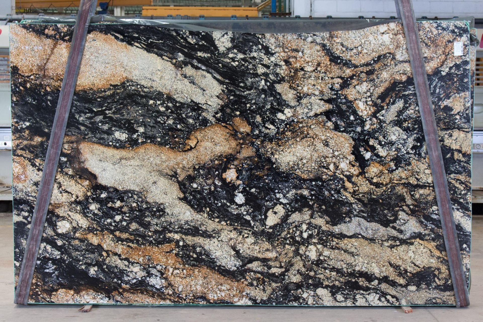 Large slab of granite with a swirling pattern of black, gold, and white.