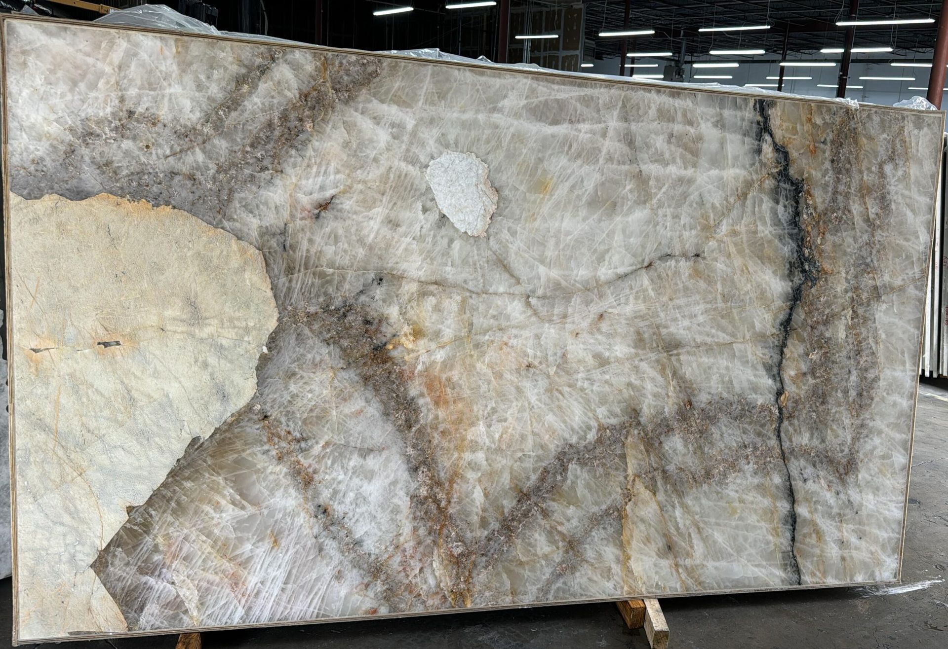 Large slab of light brown, gray, and tan stone with dark veining and some light patches.