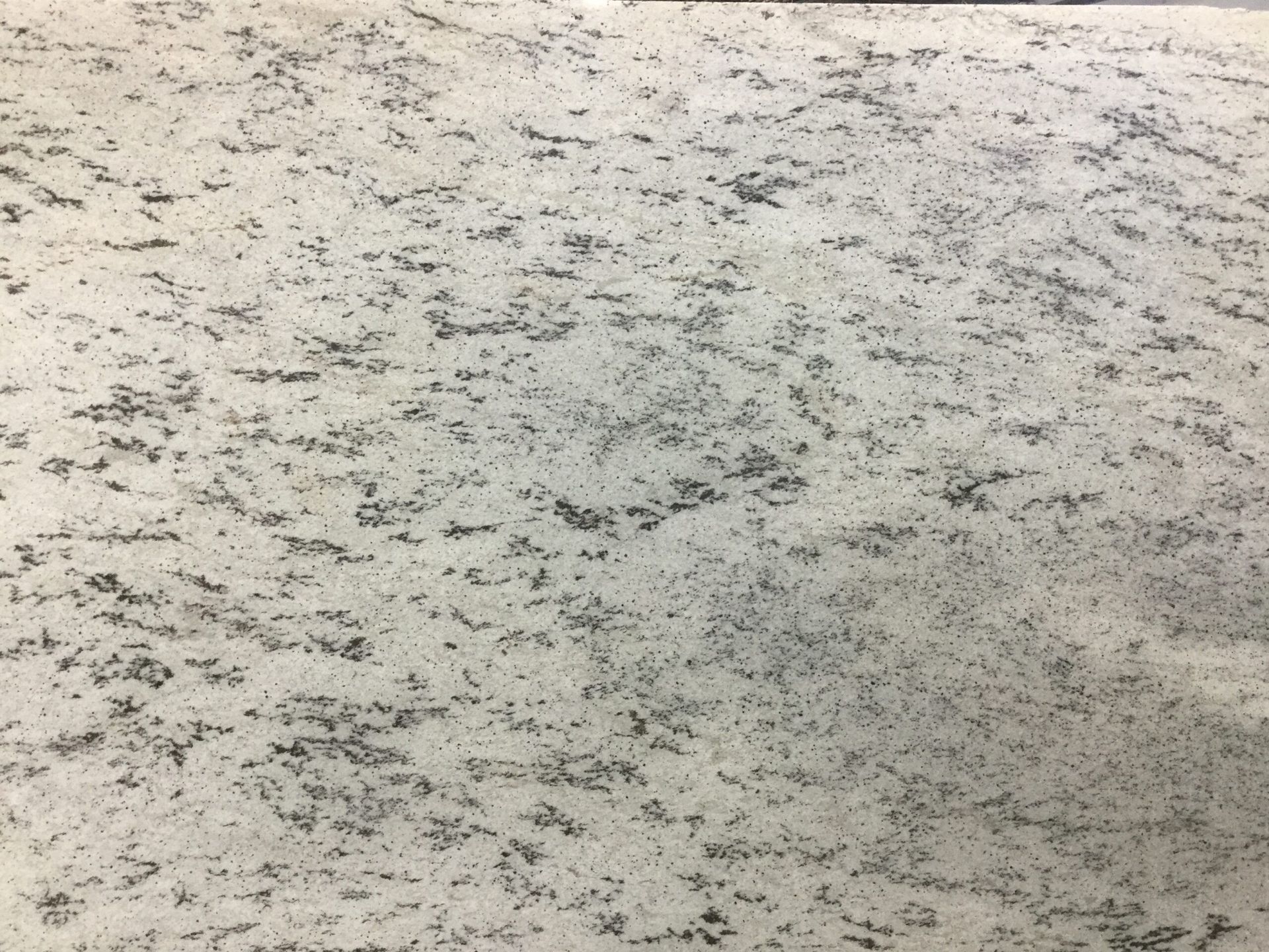 White granite countertop with speckled gray and black patterns.