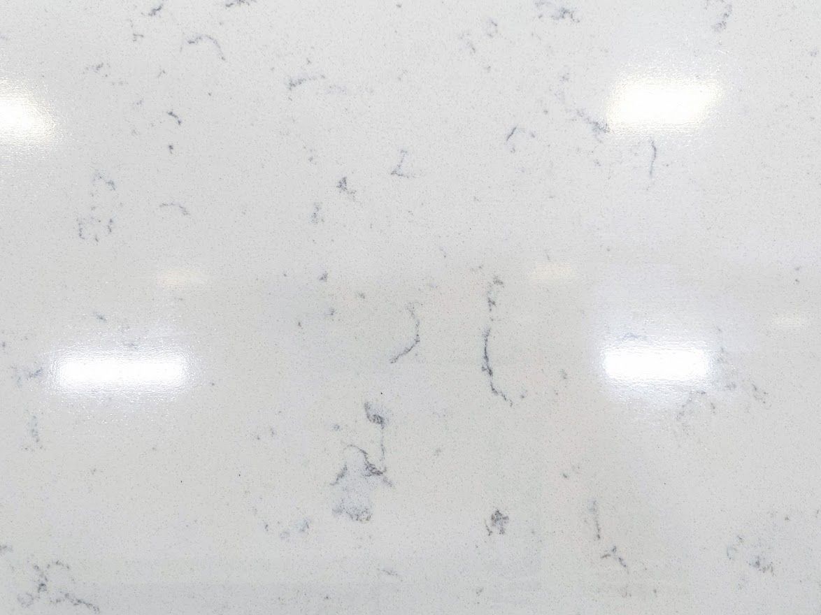 White countertop with gray veining, reflecting overhead lights.