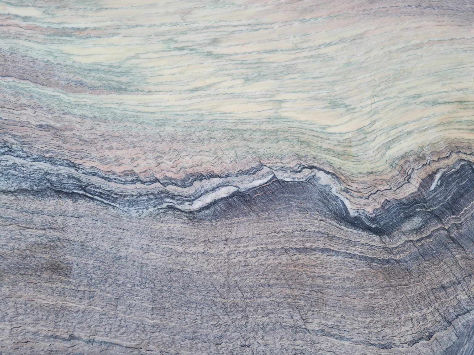 Swirling blue, gray, and cream stone texture, resembling layers of waves.