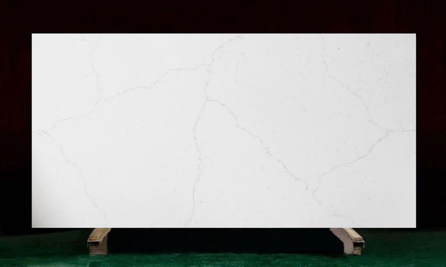 White quartz countertop with light veining, displayed on a wooden support.