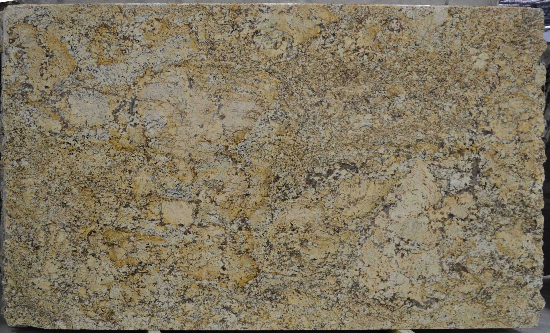 Granite slab with a mix of tan, gold, and black speckles and veining.