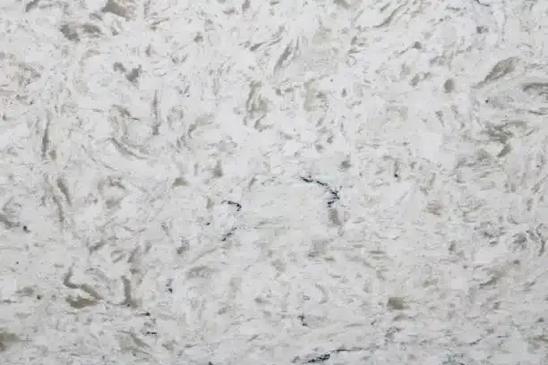 White and gray quartz countertop with swirly patterns.