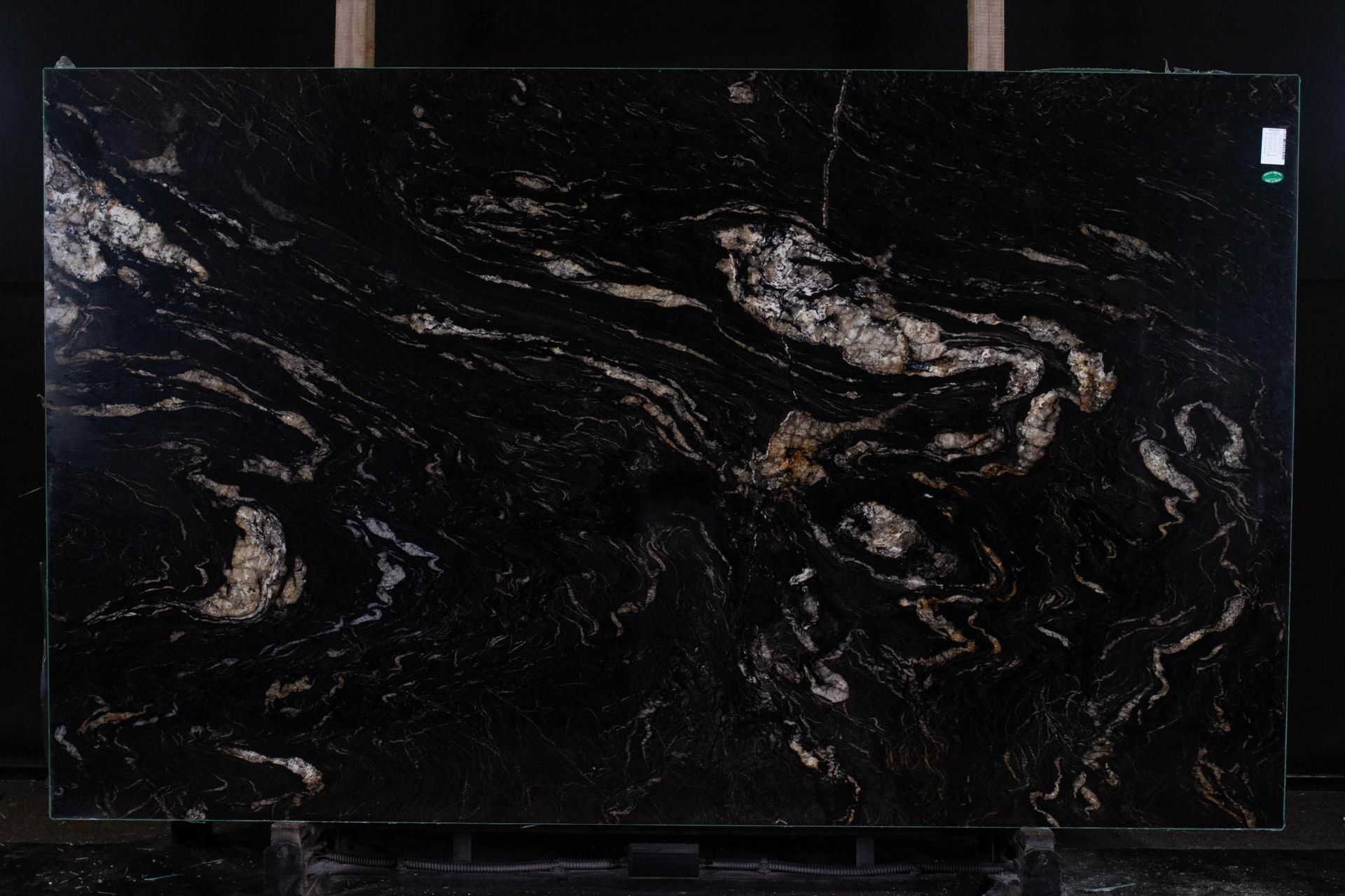 Black granite slab with swirling gold and silver veins.