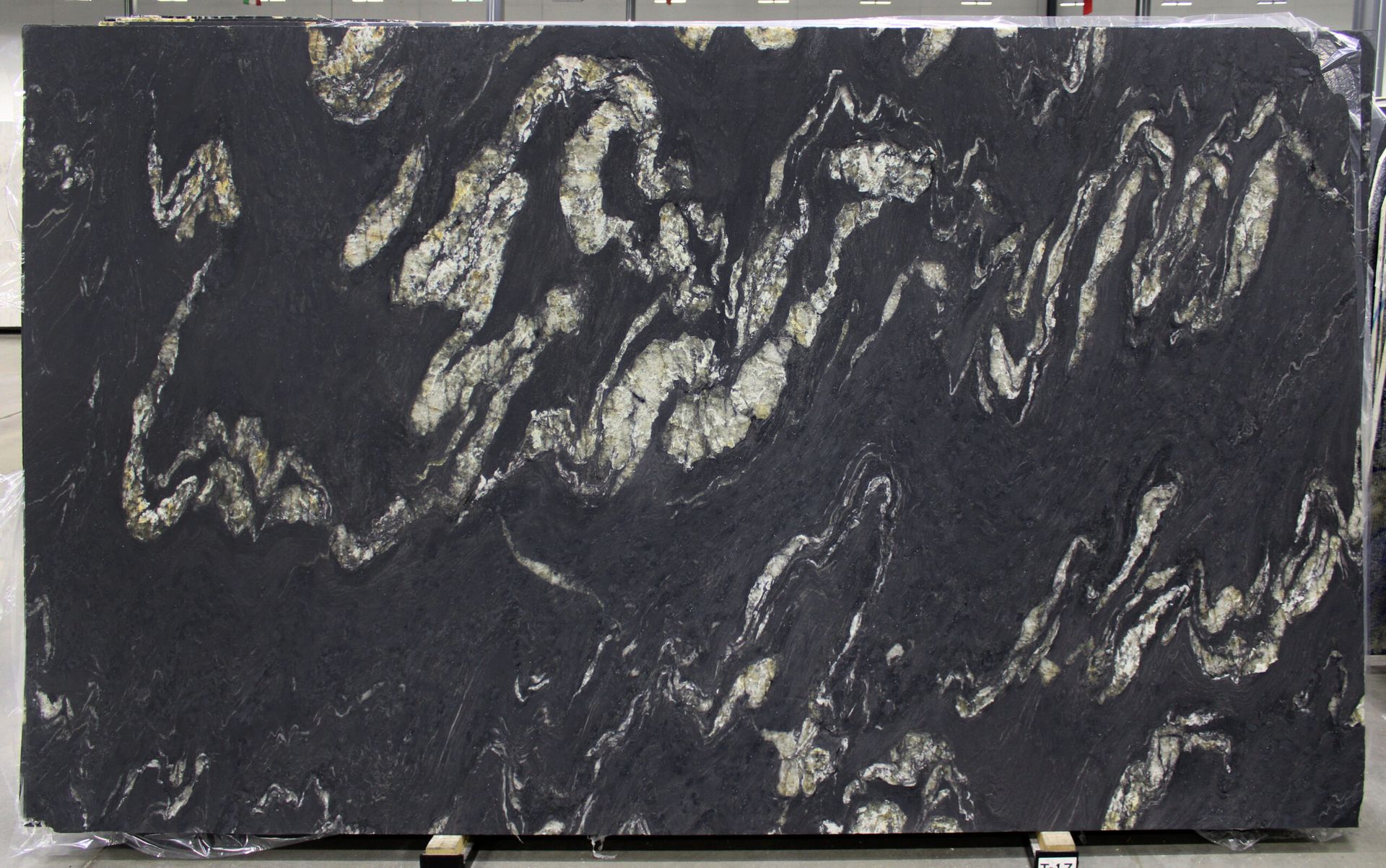 Dark granite slab with swirling light and dark patterns.