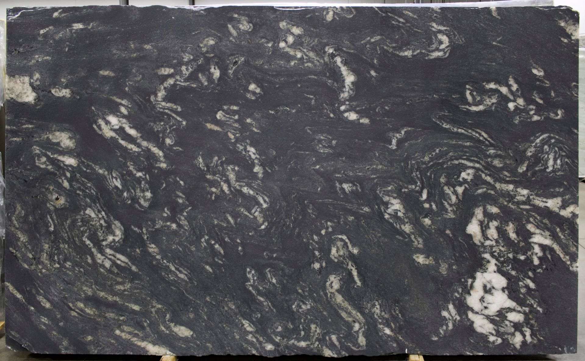 Large slab of black granite with swirling white and gray veining.