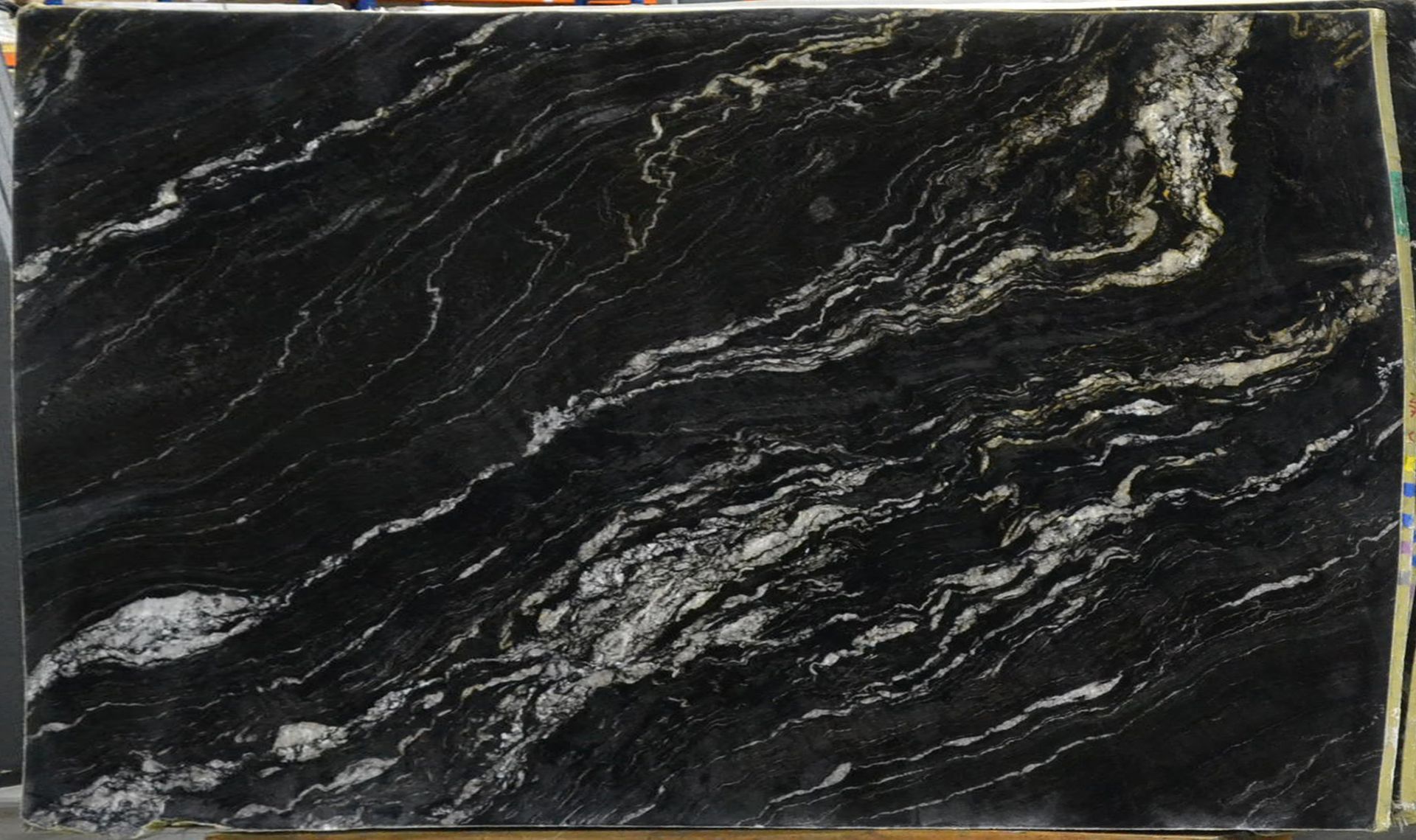 Black granite slab with white and gold veining.