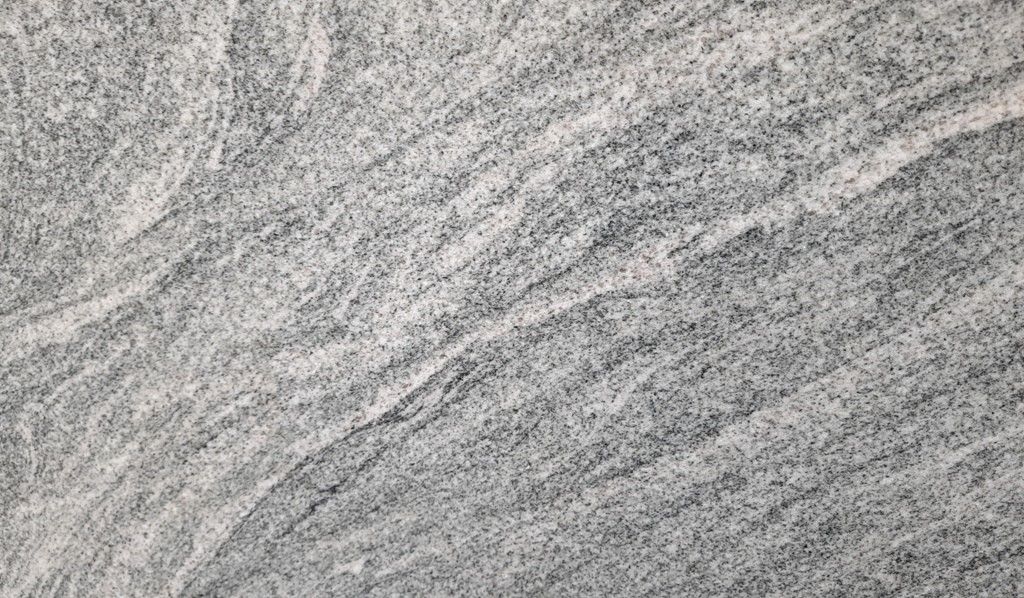 Gray textured surface with white scribbled lines.