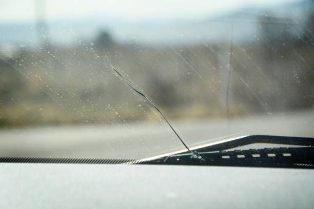 A close up of a cracked windshield on a car.