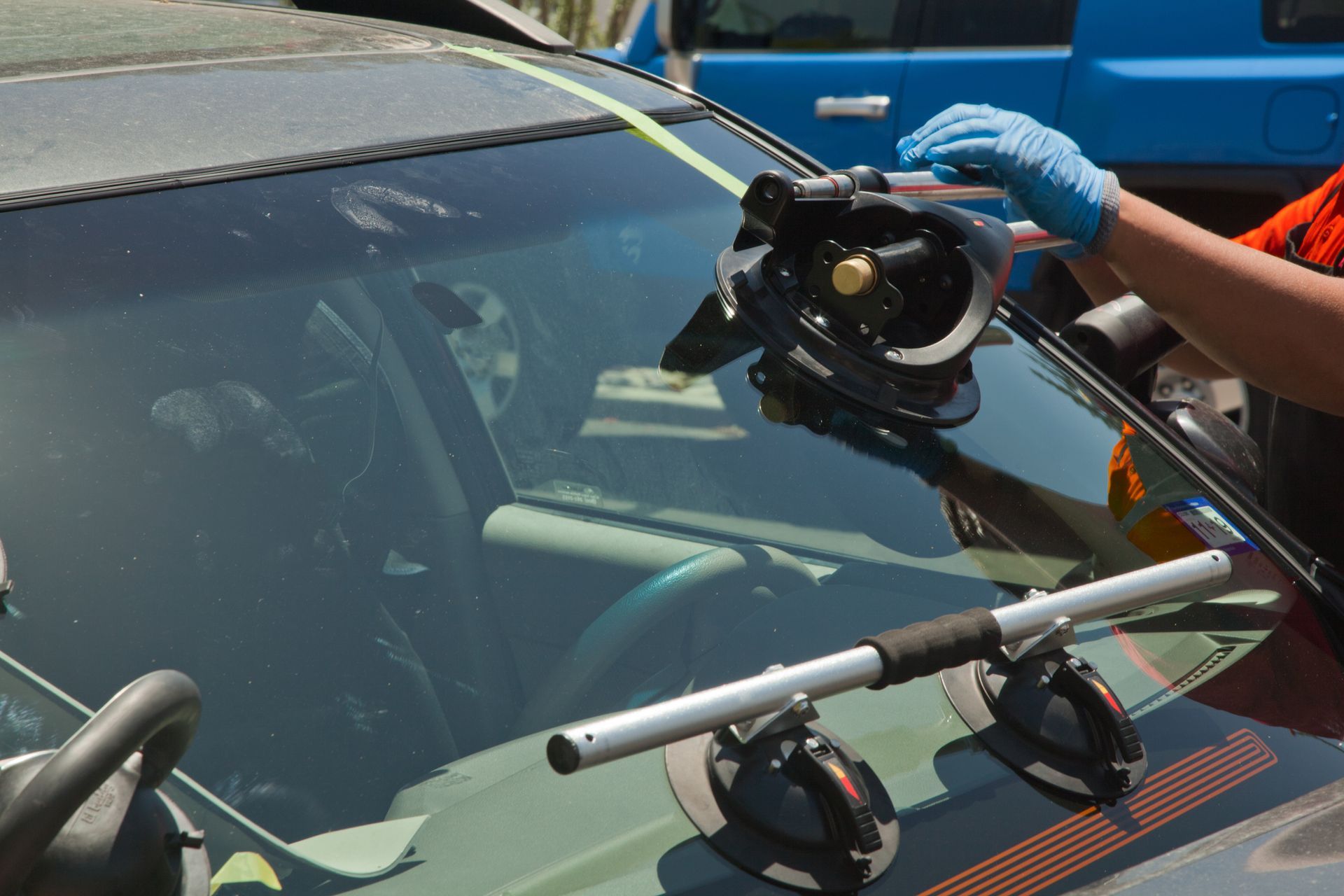 A person is installing a windshield on a car.