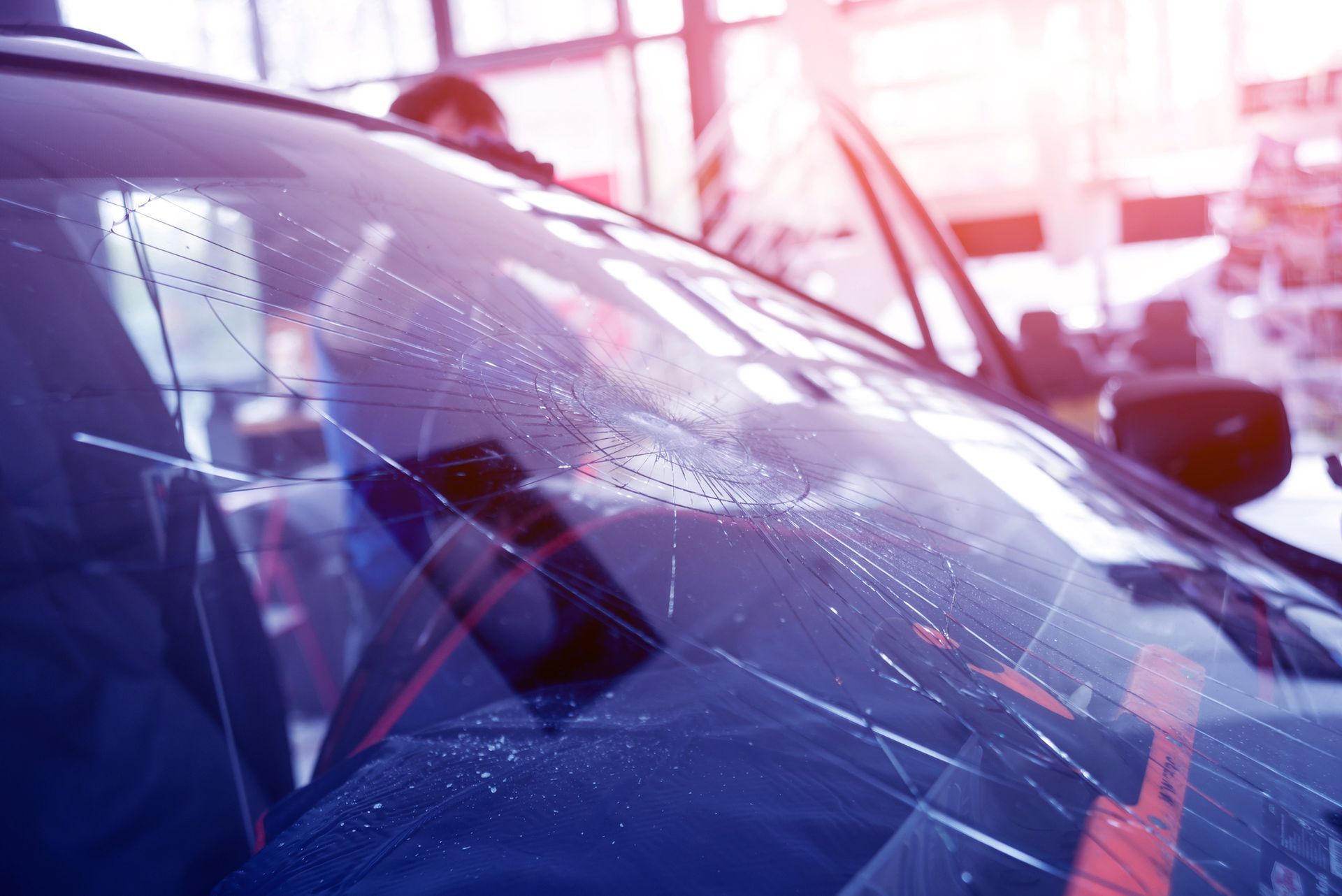 A close up of a broken windshield of a car in a showroom.