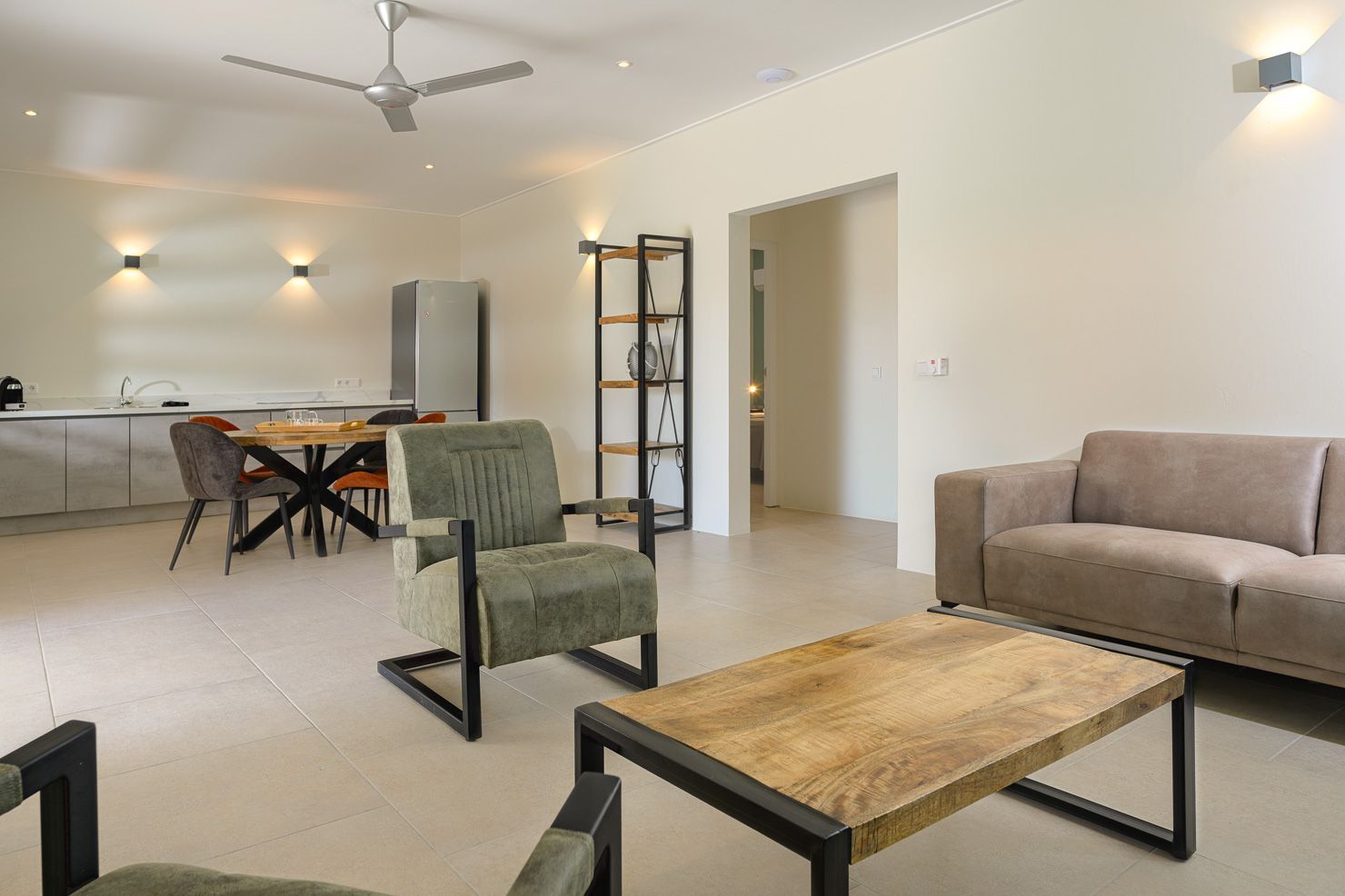 Living room with open floor plan, furniture, and kitchen area.