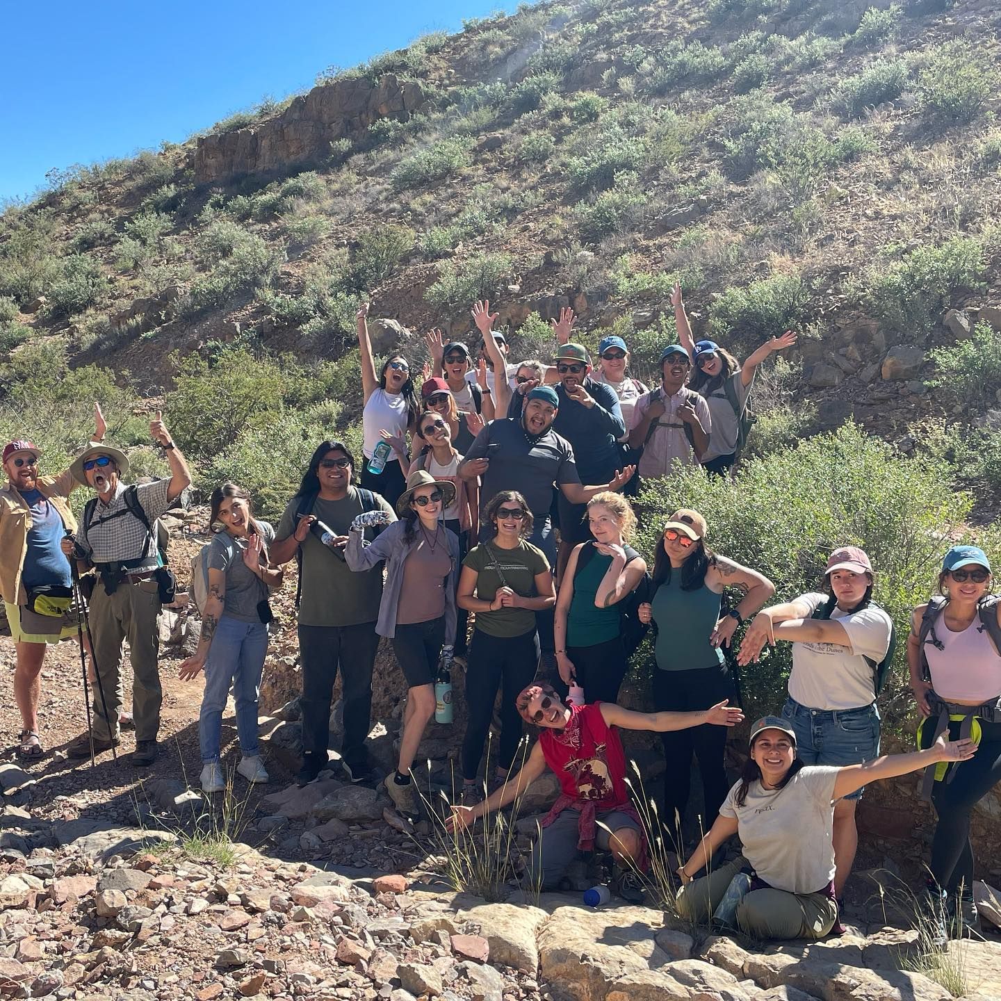 A group of people posing for a picture with their arms in the air with national conservation lands foundation