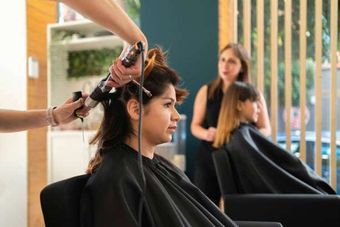 A woman is getting her hair done at a hair salon.