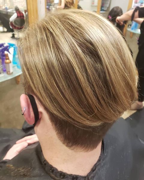 A woman is getting her hair cut in a salon.