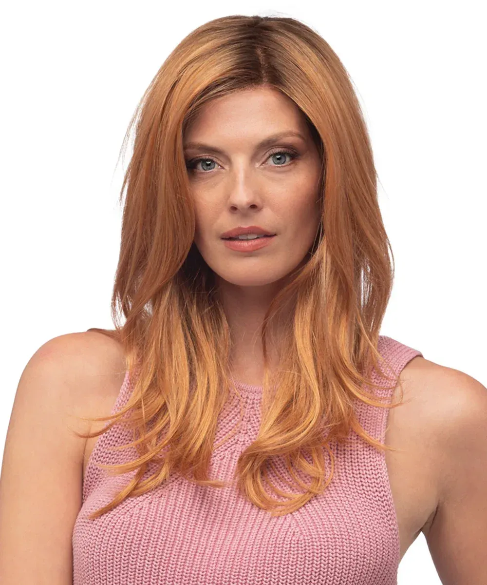 A woman with long red hair is wearing a pink tank top.