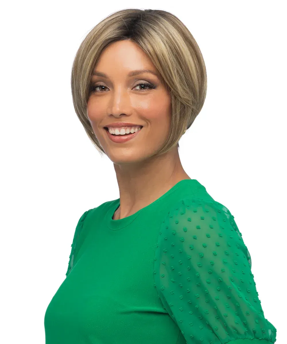 A woman wearing a green shirt and a wig is smiling