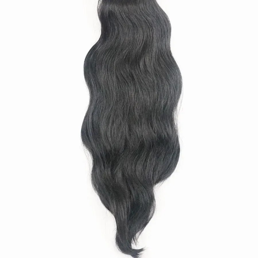 A close up of a piece of black hair on a white background.