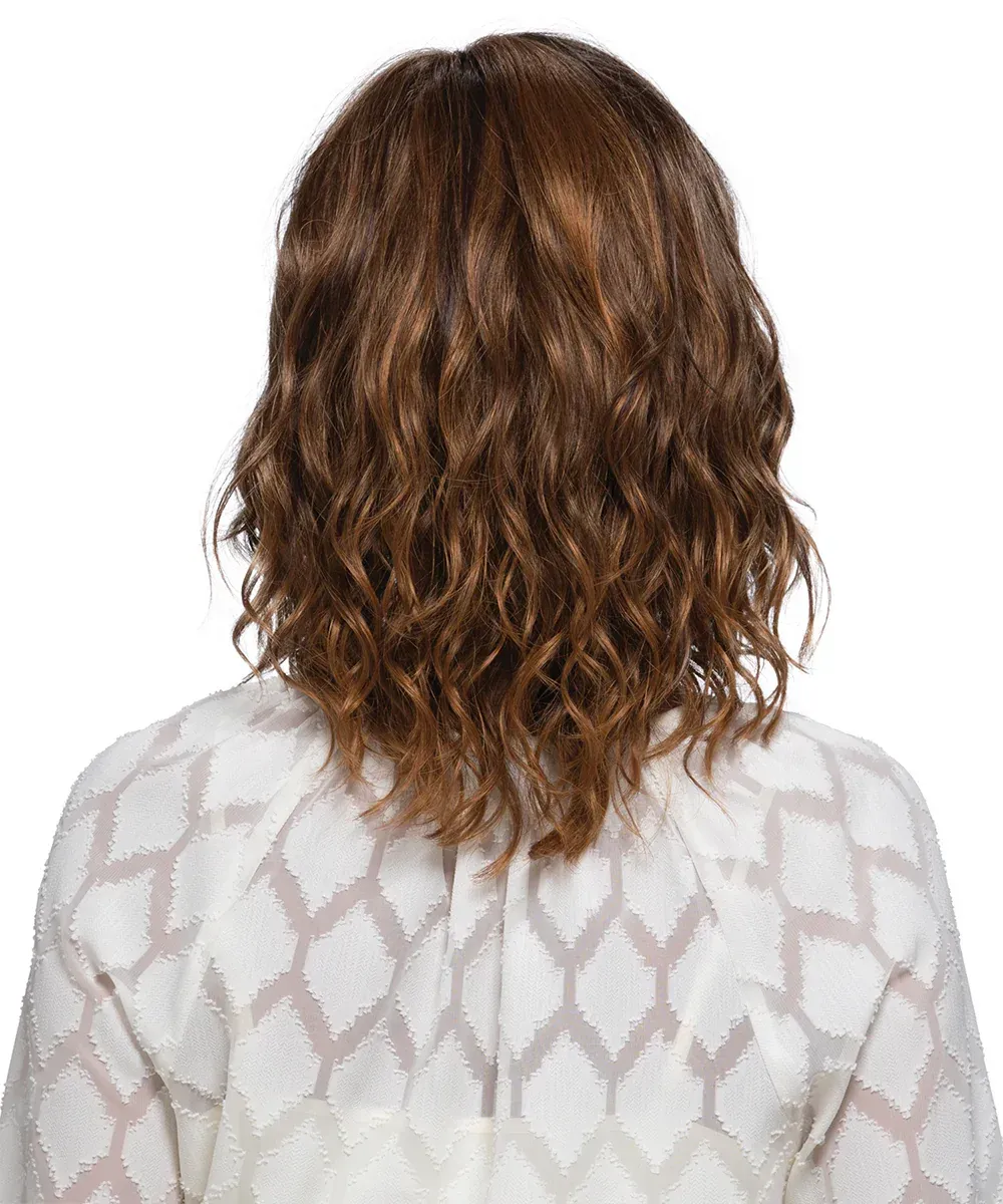 Woman with wavy brown hair and a white top, smiling.