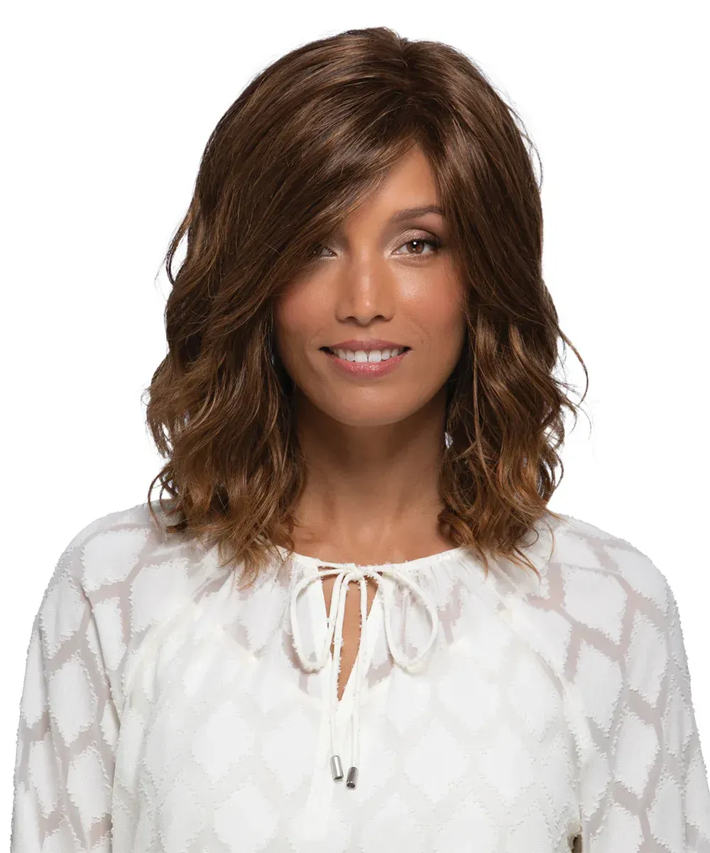 Woman with wavy brown hair and a white top, smiling.