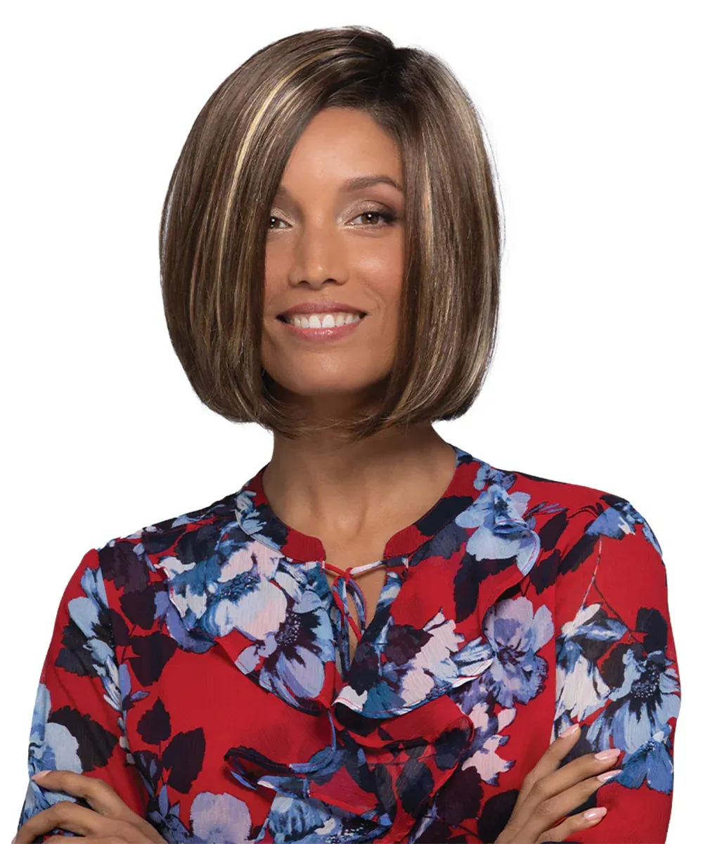 A woman wearing a wig and a floral shirt is smiling.