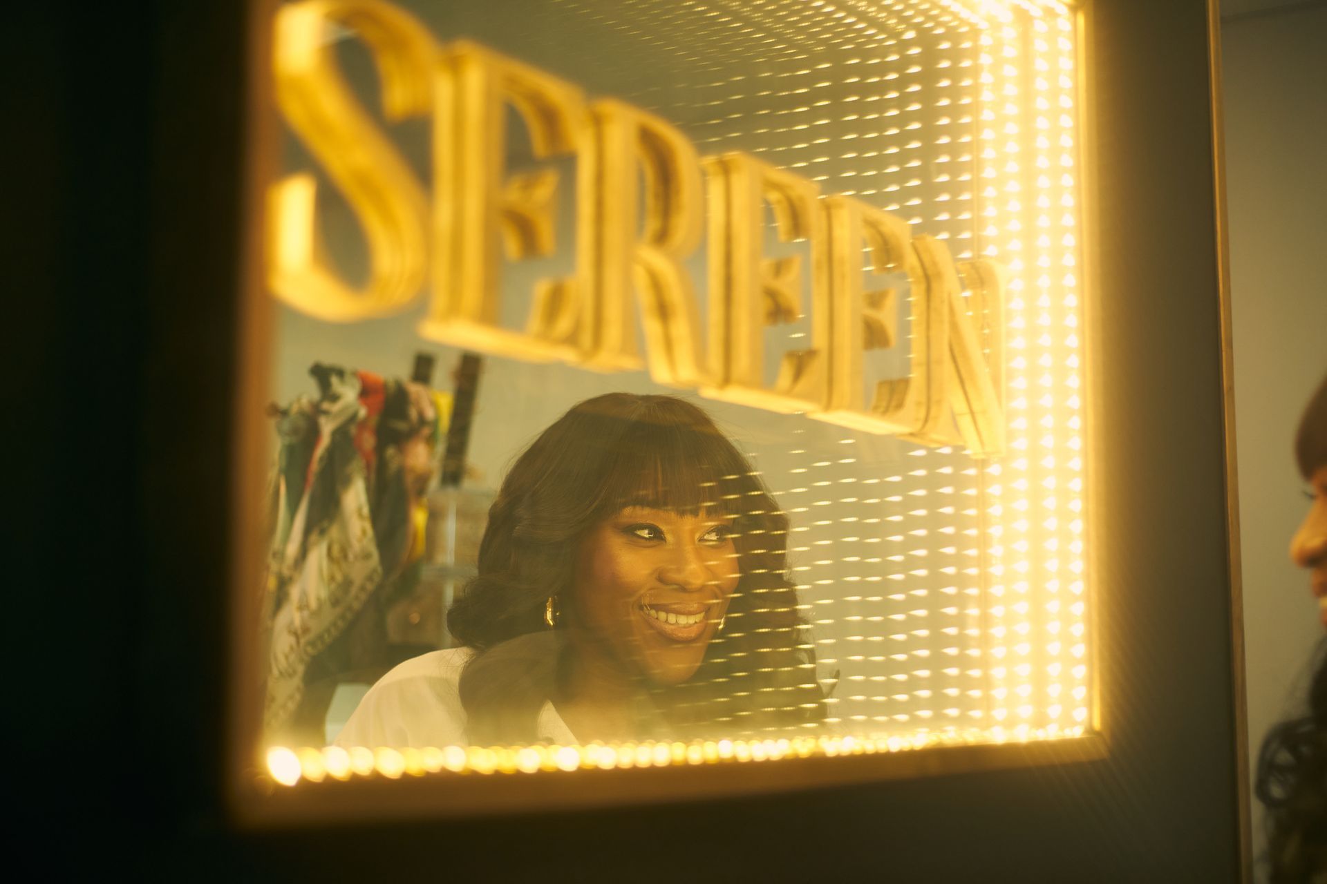 Woman smiles in a mirror with 