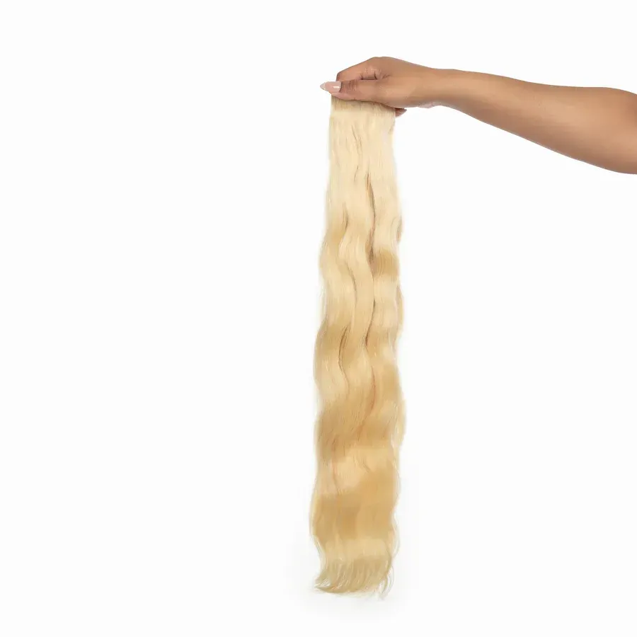 A close up of a piece of blonde hair on a white background.