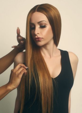 A woman with long brown hair is getting her hair done