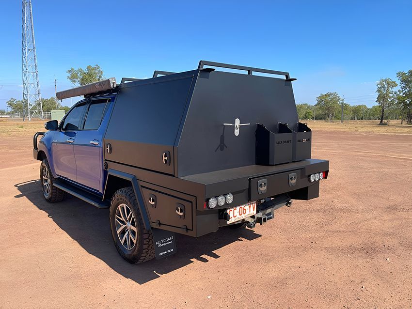 A Blue Truck with a Black Canopy is Parked in a Dirt Field — Allycraft Modifications in Palmerston, NT