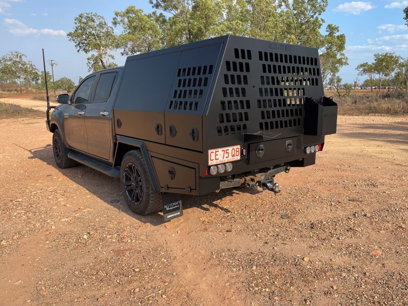 A Black Truck With a Canopy on the Back is Parked on a Dirt Road — Allycraft Modifications in Berrimah, NT